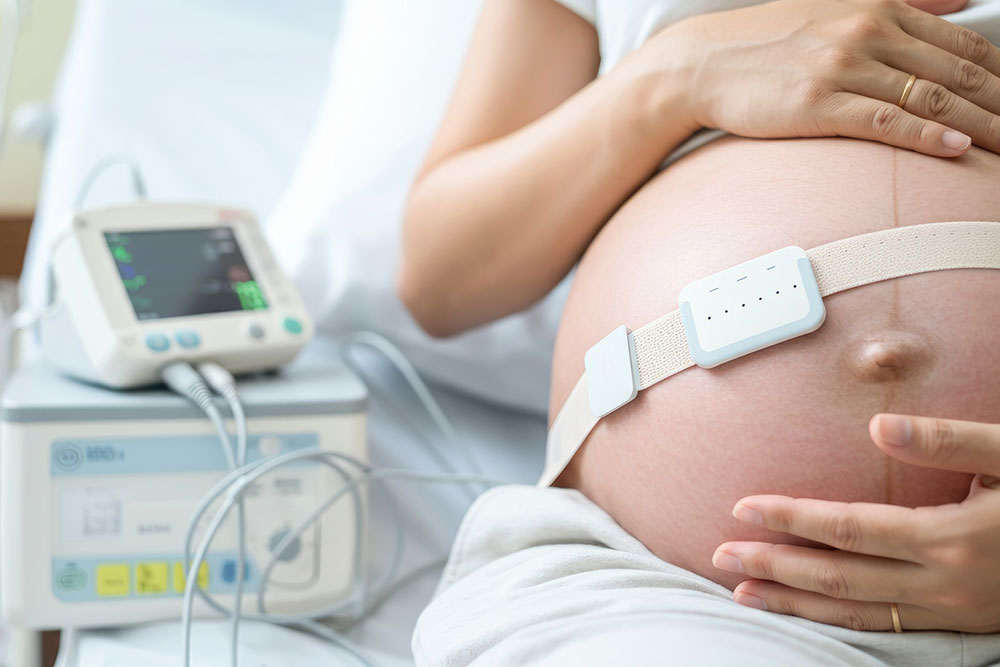 Pregnant patient monitored in a hospital bed representing labor and delivery care and potential birth injury risks