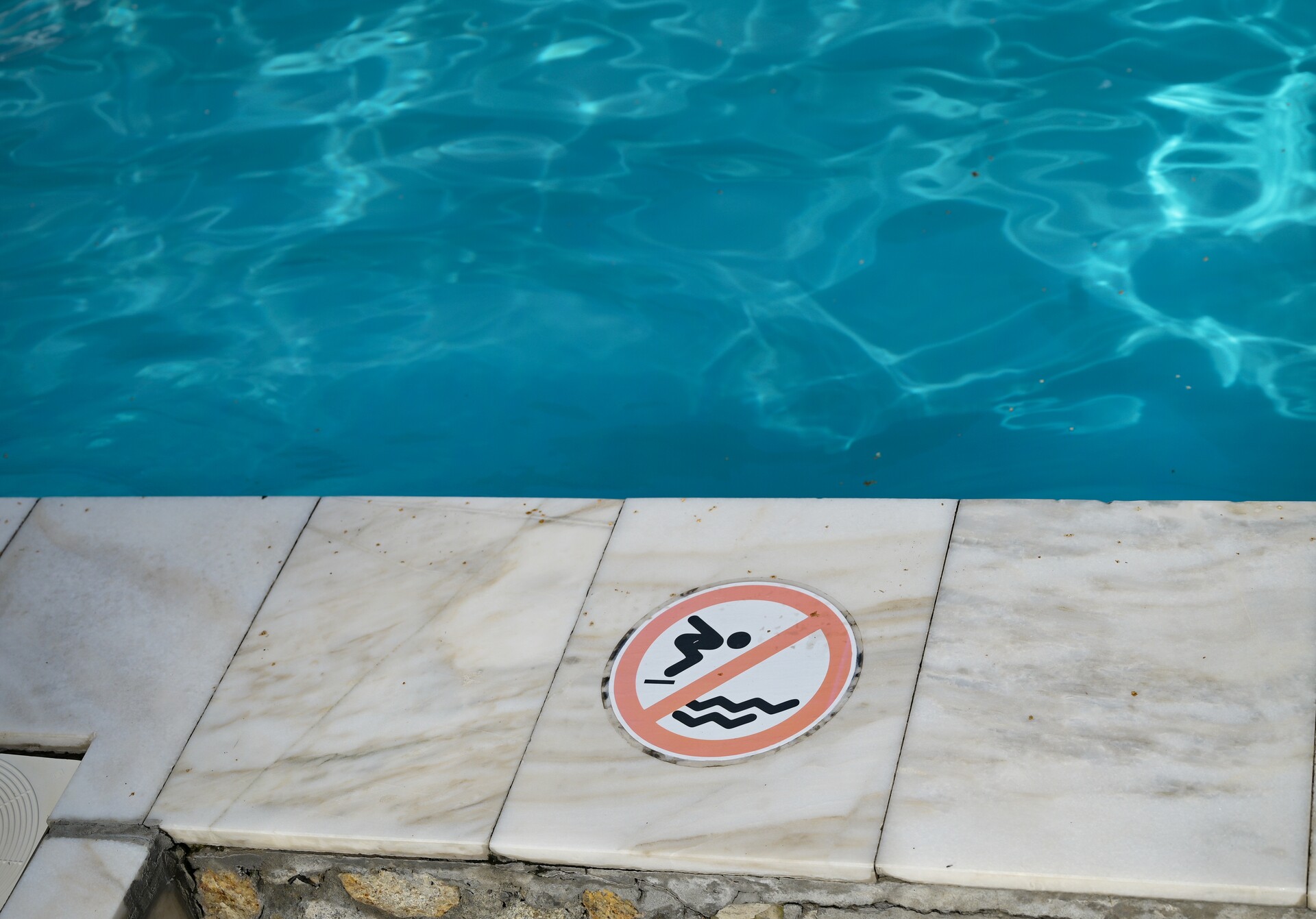 Do not jump into water warning sign near a swimming pool representing duty to warn of hazards