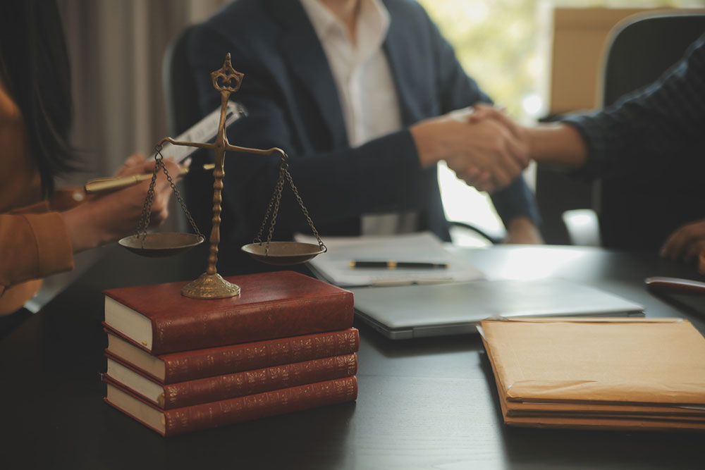 Attorney presenting a signed document to a client with a gavel on the table