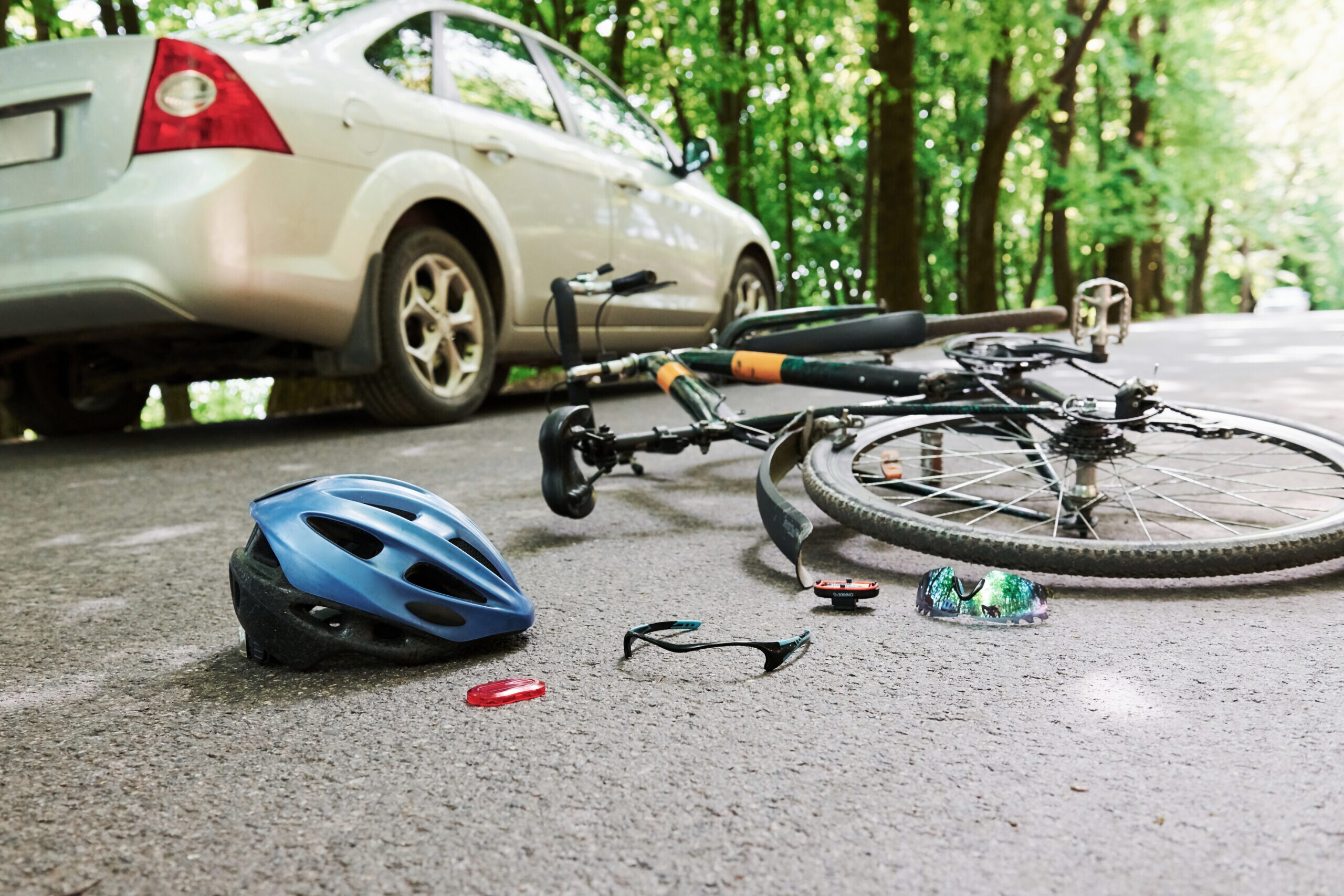 Bicycle crash scene with helmet on road near car representing traumatic brain injury accident in Tampa Florida