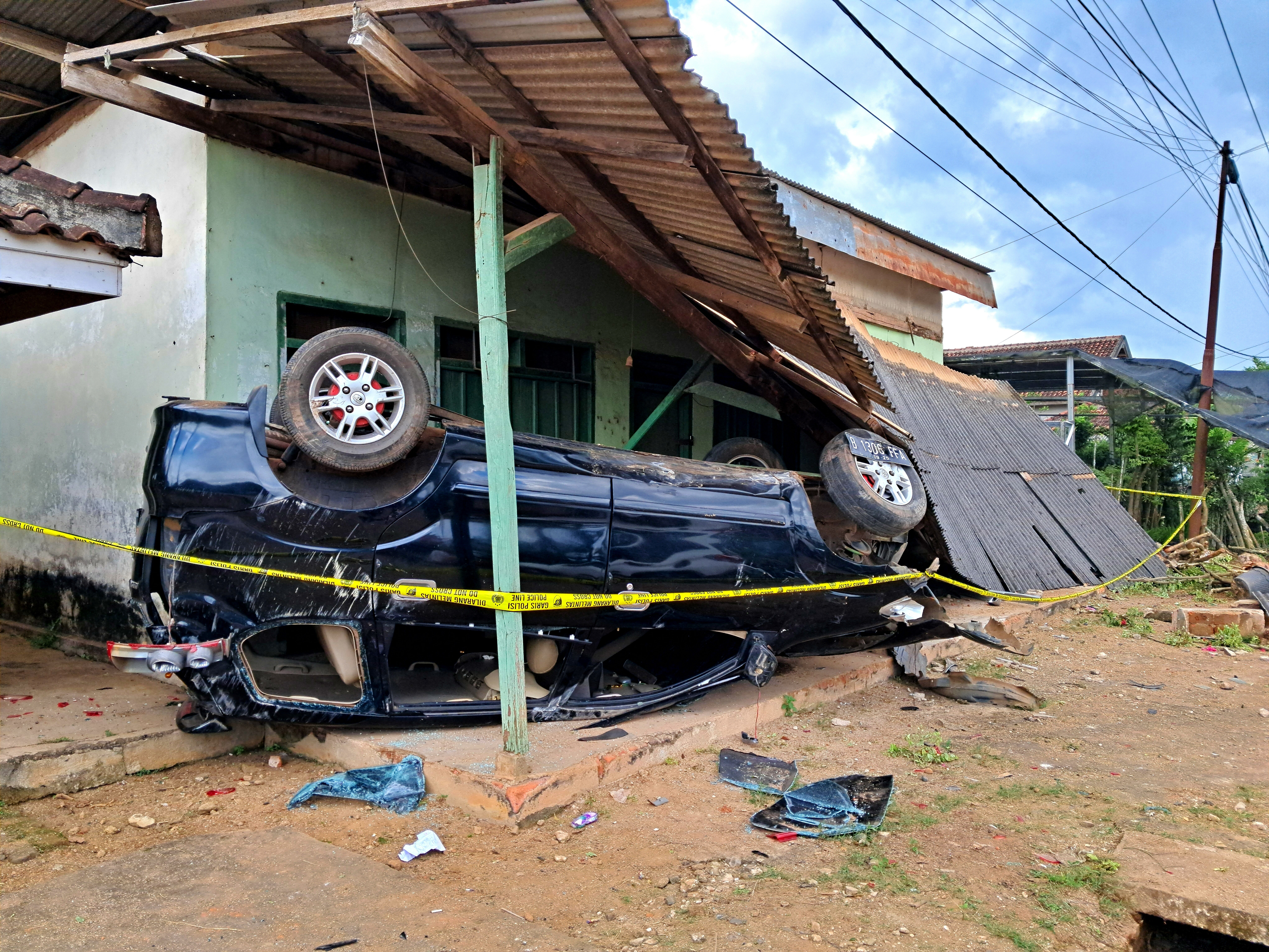 Overturned vehicle crashed into house representing serious crash caused by driver fatigue in Tampa Florida