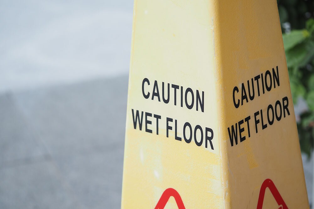 Caution sign indicating a wet floor in a public area representing a slip and fall hazard