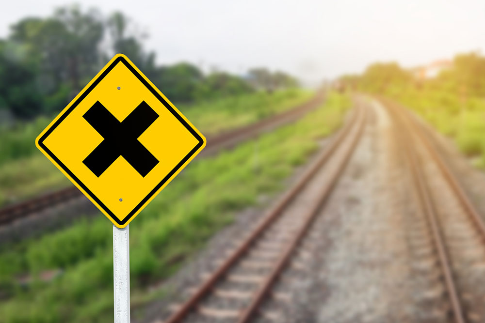 Train crossing warning sign representing railroad crossing safety and crash risk