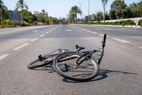 Damaged bicycle lying on road after traffic accident
