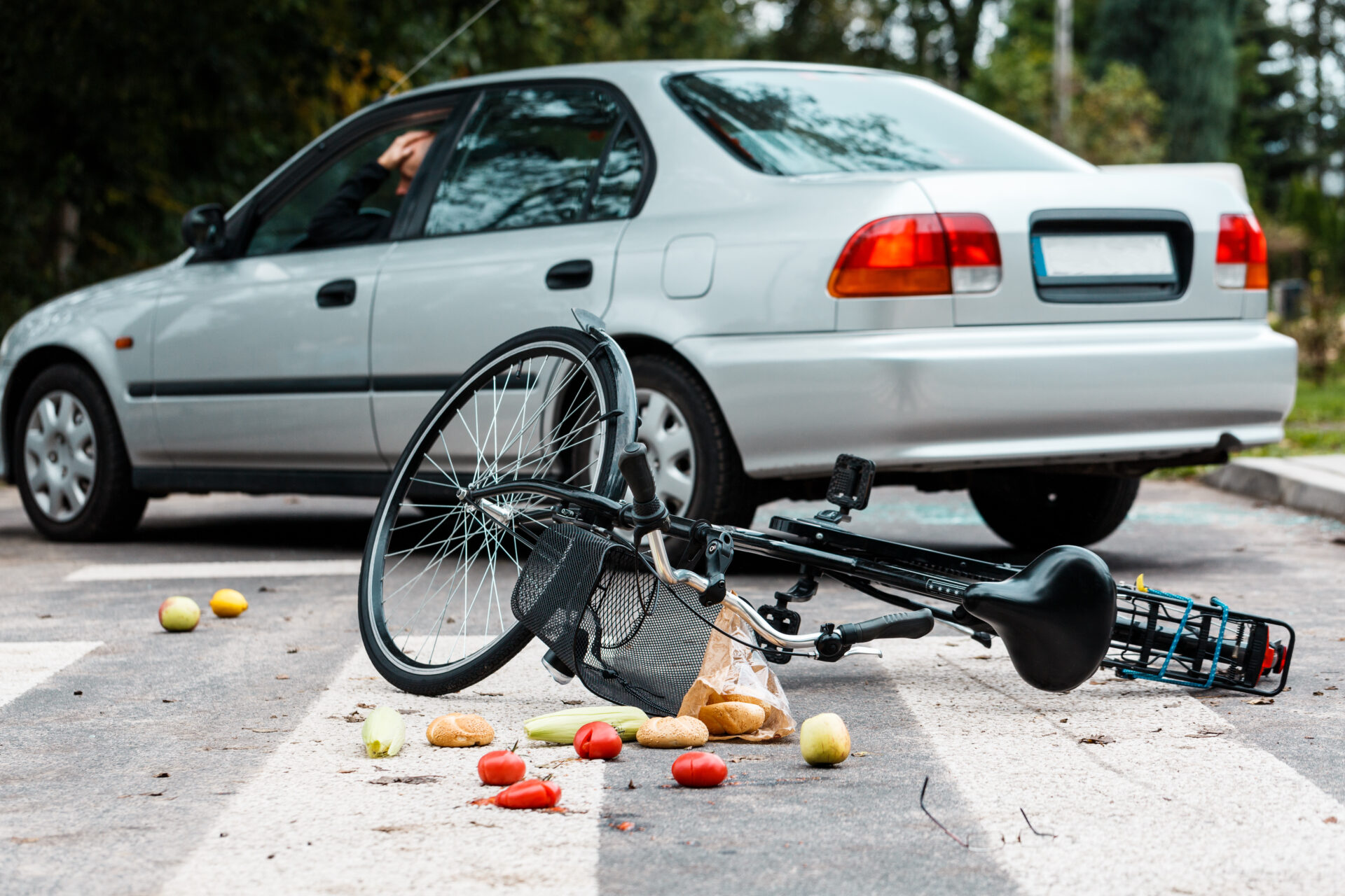 Worried driver looking in the side mirror after hitting a cyclist on a pedestrian crossing