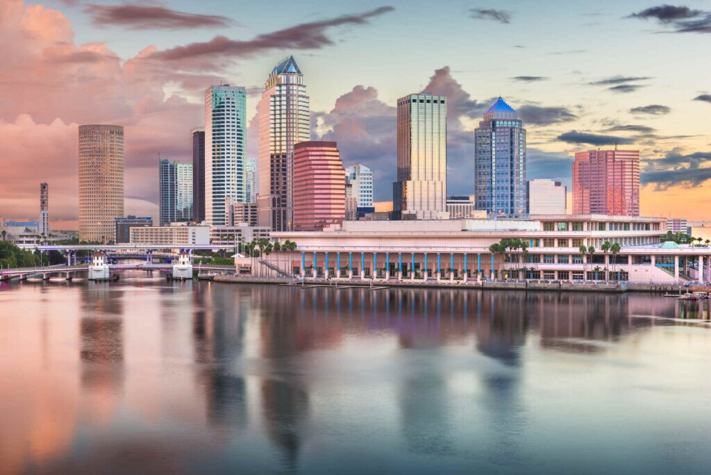 The downtown skyline reflected over the water at sunset in the Tampa Personal Injury legal service area.