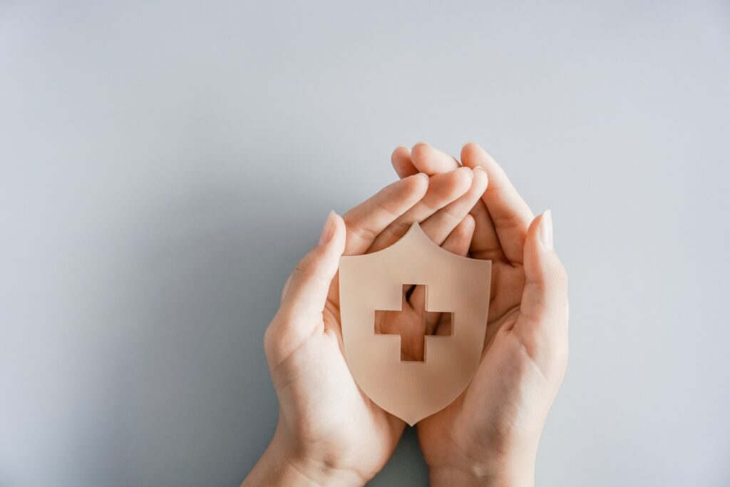 Hands holding a protective medical shield icon advocate for client safety with a St. Petersburg Personal Injury Lawyer.